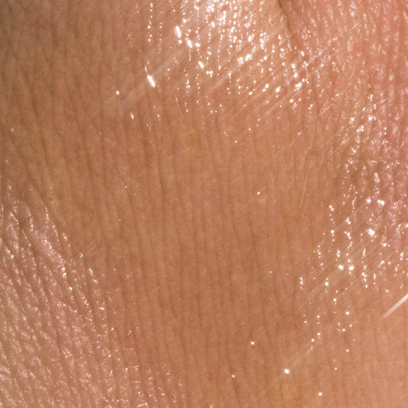 Applying antioxidant face serum to cheek in morning skincare routine
