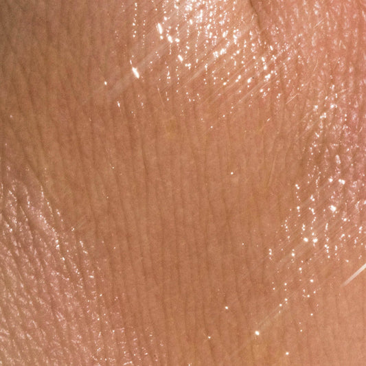 Applying antioxidant face serum to cheek in morning skincare routine