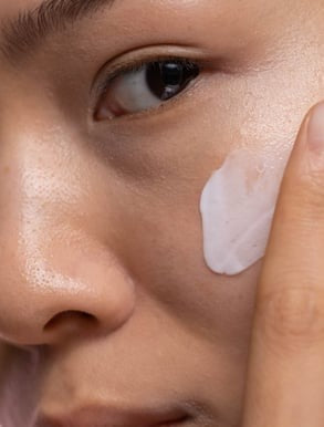 Applying night cream to face before bedtime skincare routine