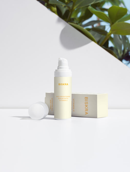 "Bottle of Face Brightening Serum with Vitamin C on a minimalist white background."