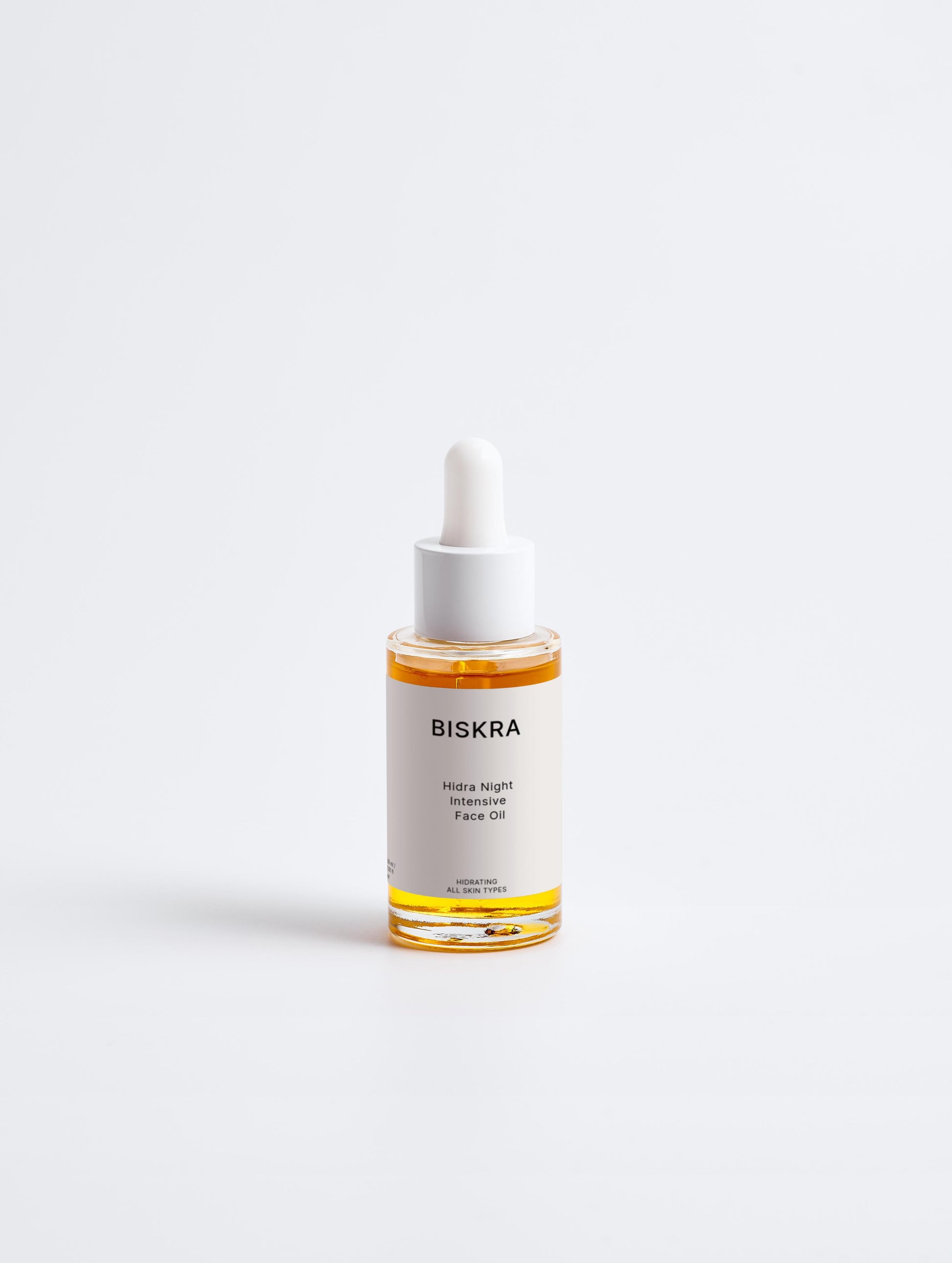 Close-up of dropper dispensing Intensive Recovery Face Oil onto hand