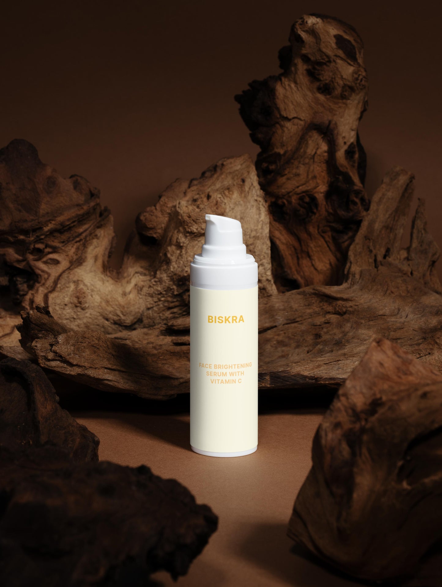 "Dropper dispensing Vitamin C serum onto the back of a hand."
