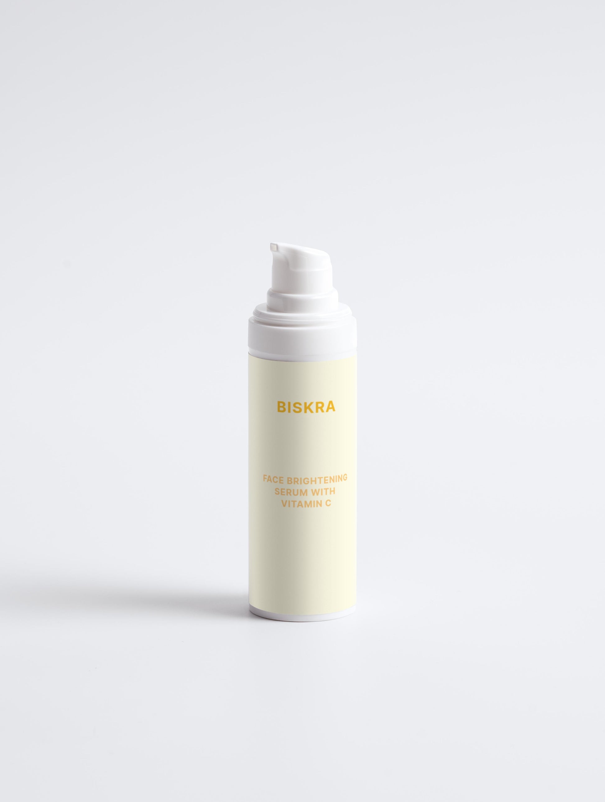 "Flat lay of Face Brightening Serum with other Biskra skincare products on a marble tray."