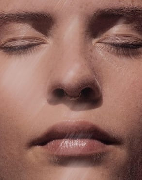 Model applying luxury serum to glowing, healthy skin