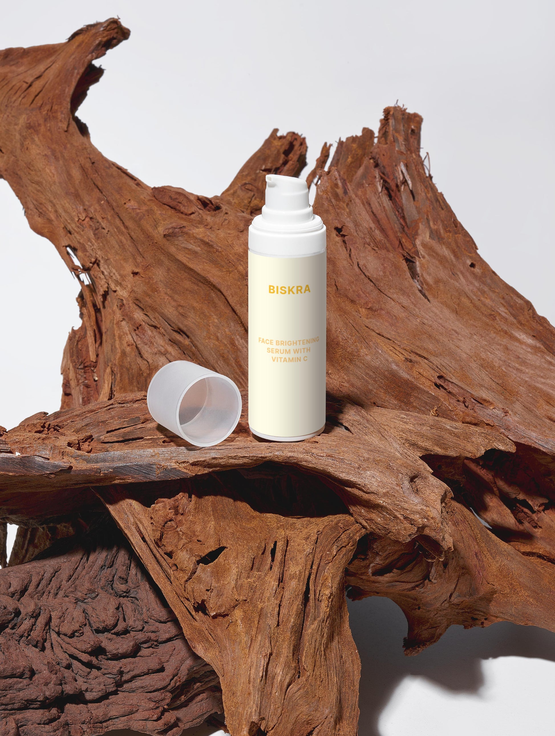 "Vitamin C Brightening Serum with packaging, surrounded by natural oils and botanicals."