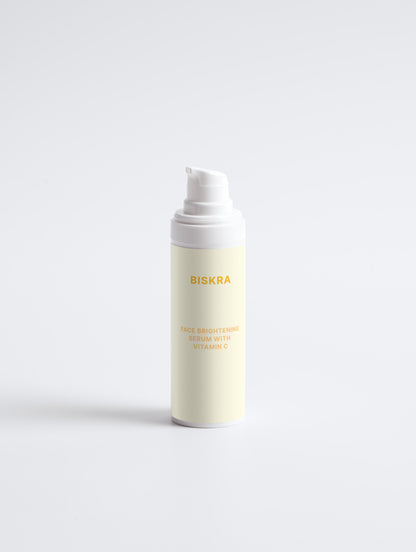 "Flat lay of Face Brightening Serum with other Biskra skincare products on a marble tray."